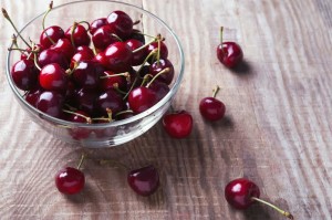 Cherries in a glass bowl on the wooden table